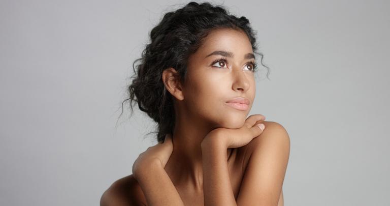 Happy serene young woman with beautiful olive skin.