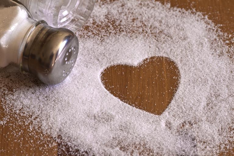 A salt shaker spilled out into a heart shape